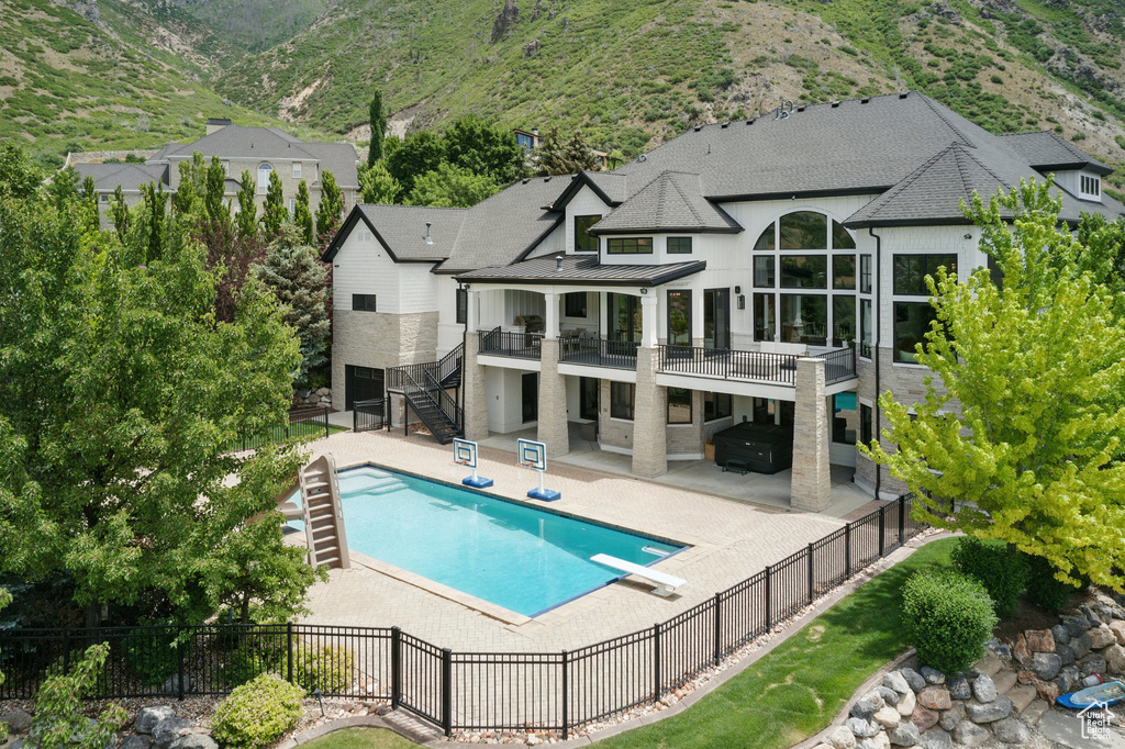Back of property featuring stairway, a fenced backyard, a standing seam roof, and a patio