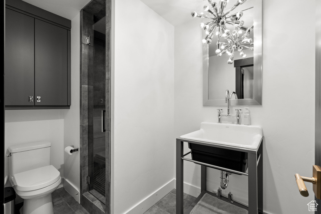 Full bath featuring a shower stall and a chandelier