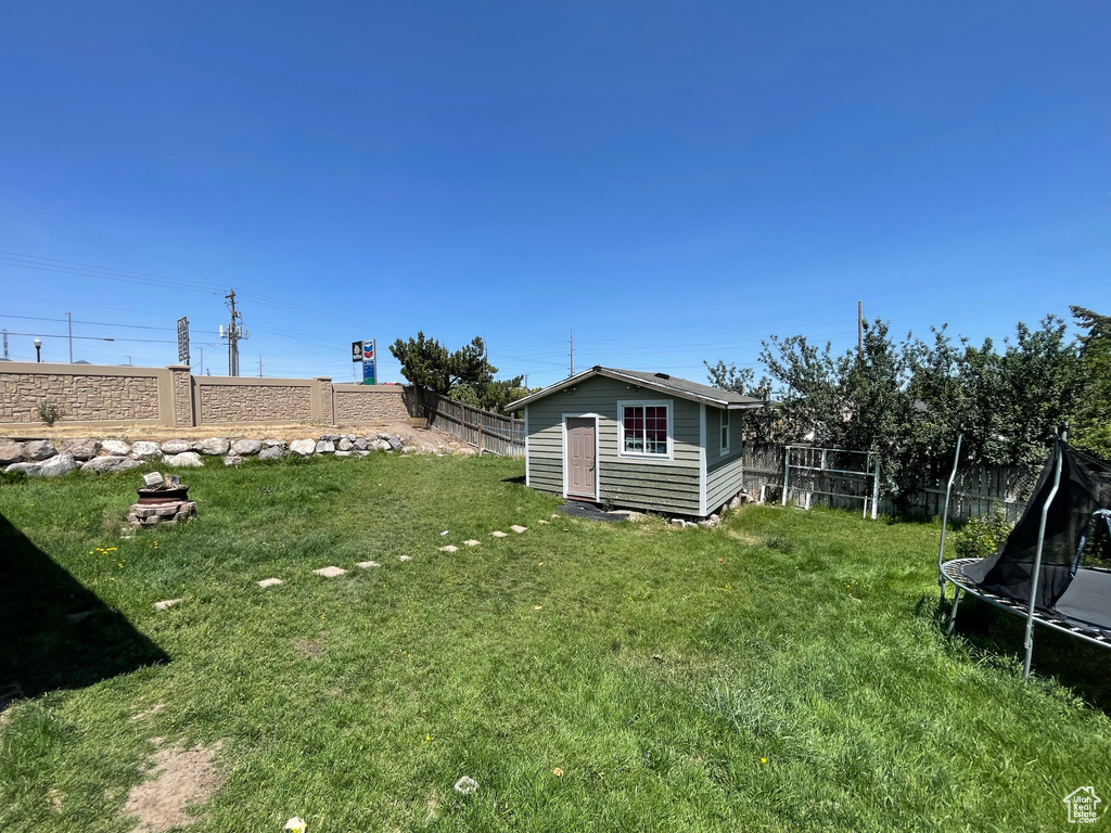 Fenced backyard with a trampoline and an outdoor structure