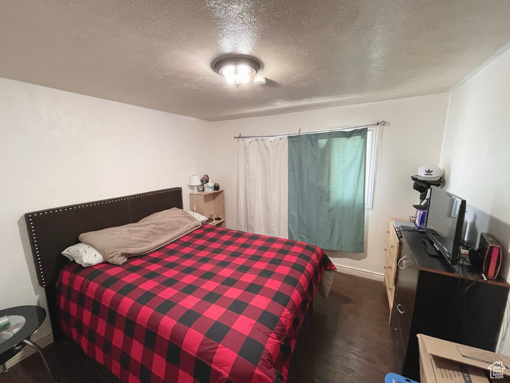 Bedroom with a textured ceiling and dark carpet