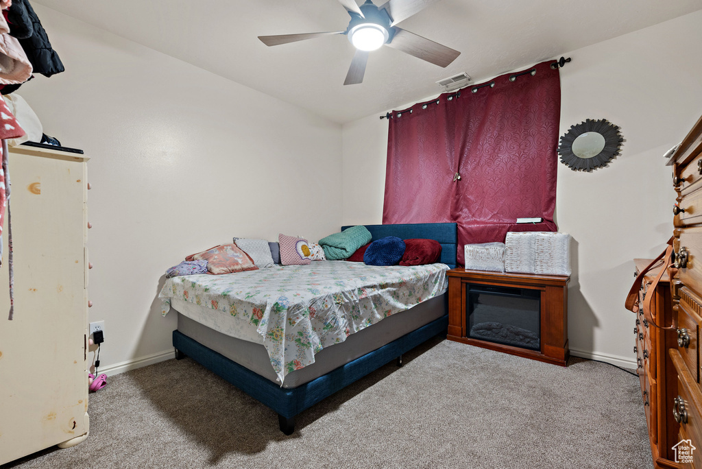 Carpeted bedroom featuring baseboards and a ceiling fan