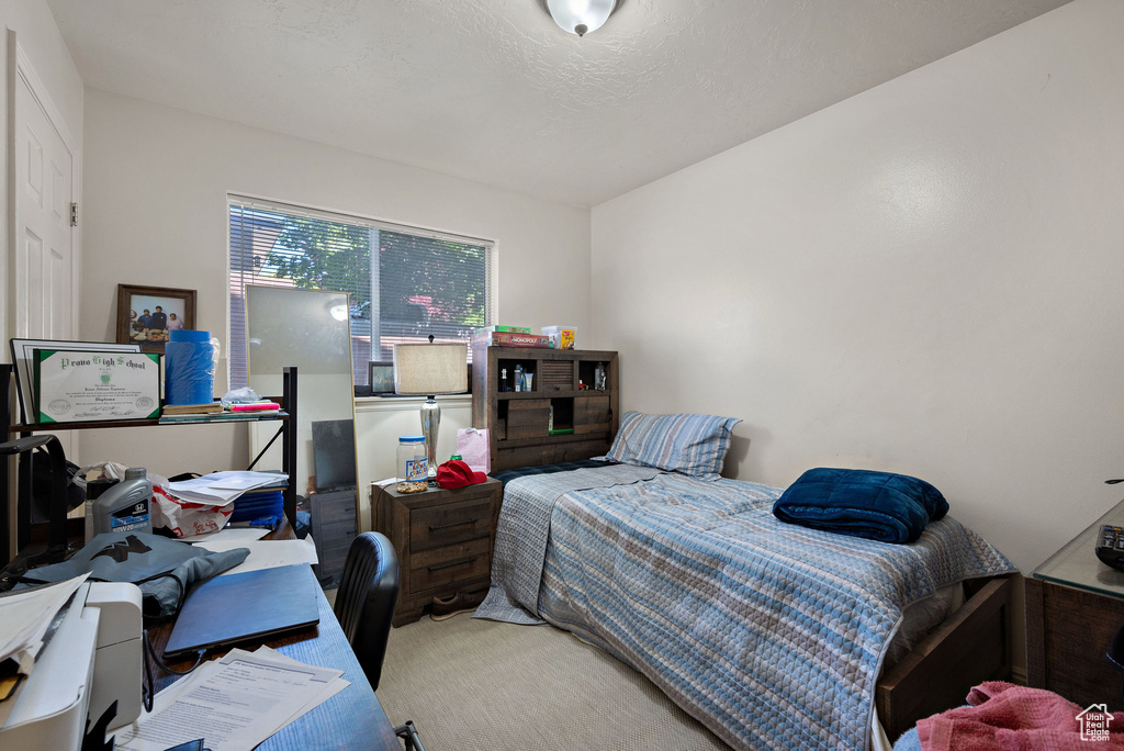 Carpeted bedroom featuring a desk