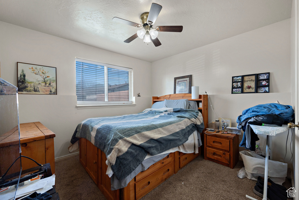 Carpeted bedroom featuring ceiling fan