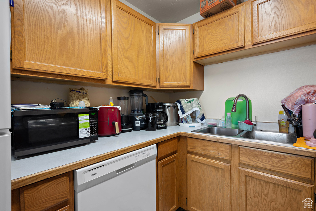 Kitchen with dishwasher, black microwave, and light countertops