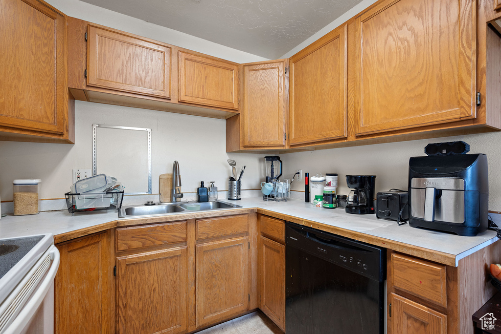 Kitchen featuring black dishwasher, light countertops, and white electric range oven