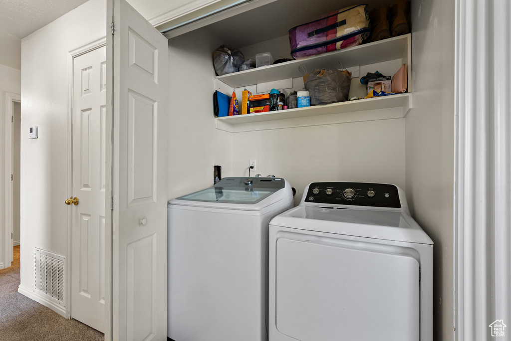 Laundry area with washer and dryer and carpet flooring