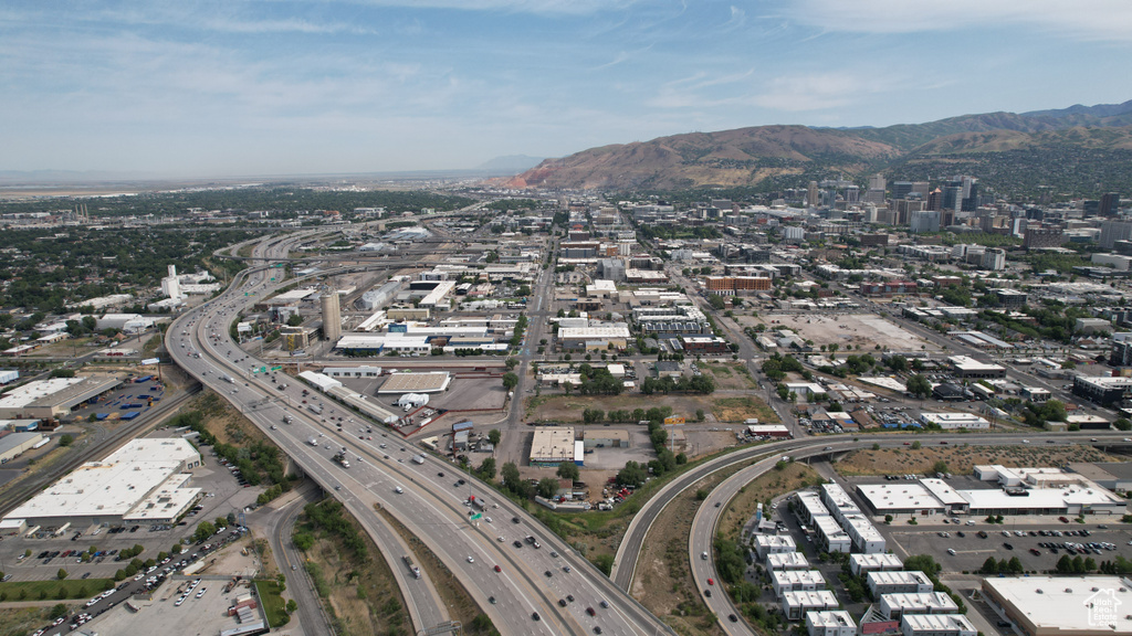Aerial view of property and surrounding area featuring a mountain backdrop
