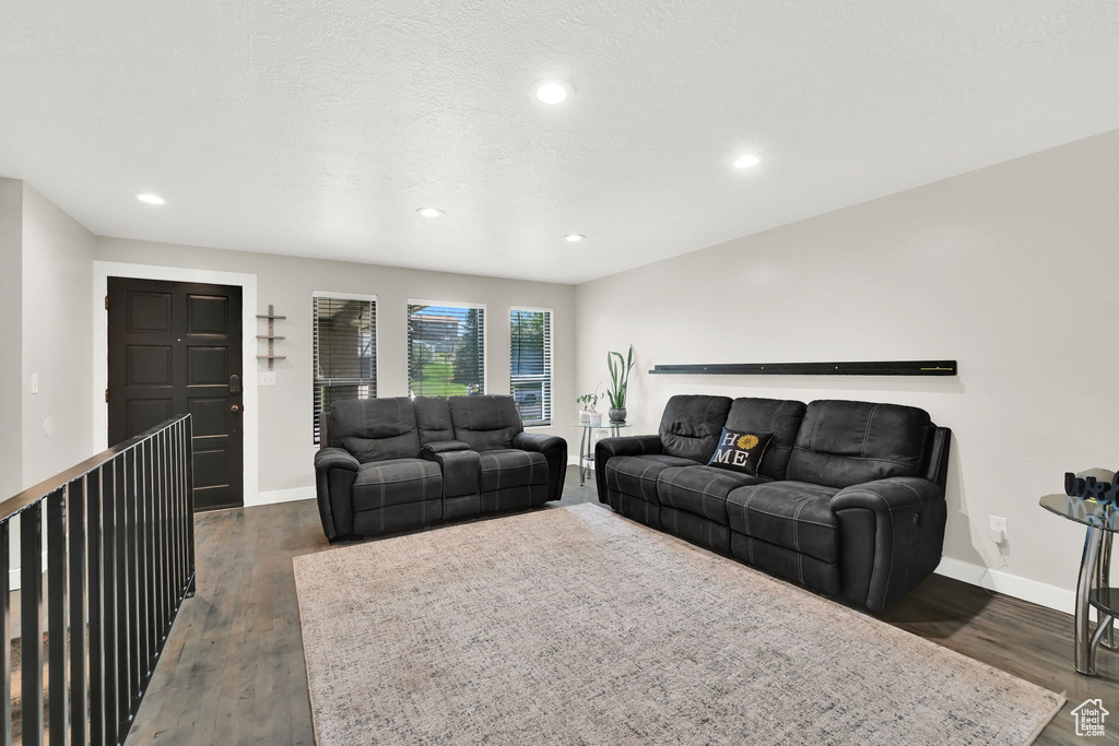 Living area featuring dark wood finished floors and recessed lighting