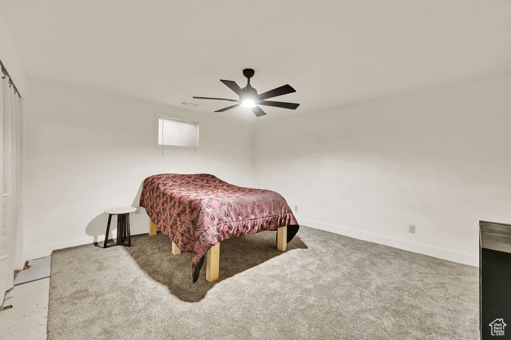 Carpeted bedroom with baseboards and a ceiling fan