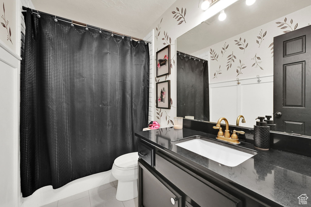 Full bathroom with vanity, tile patterned floors, and a shower with shower curtain