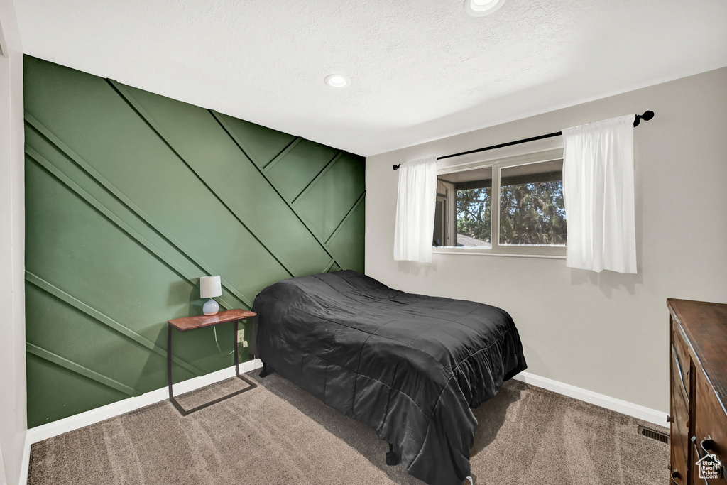 Carpeted bedroom featuring recessed lighting and a textured ceiling