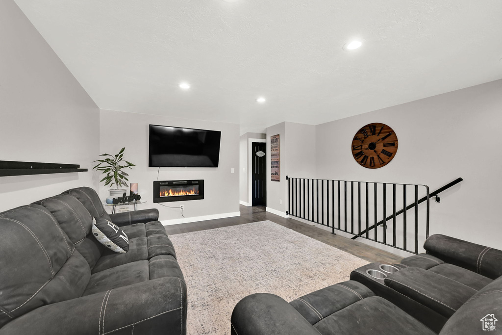 Living area with recessed lighting, wood finished floors, and a glass covered fireplace