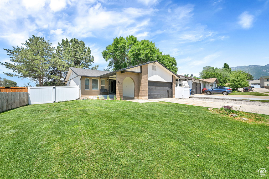 Ranch-style home featuring an attached garage, driveway, and brick siding