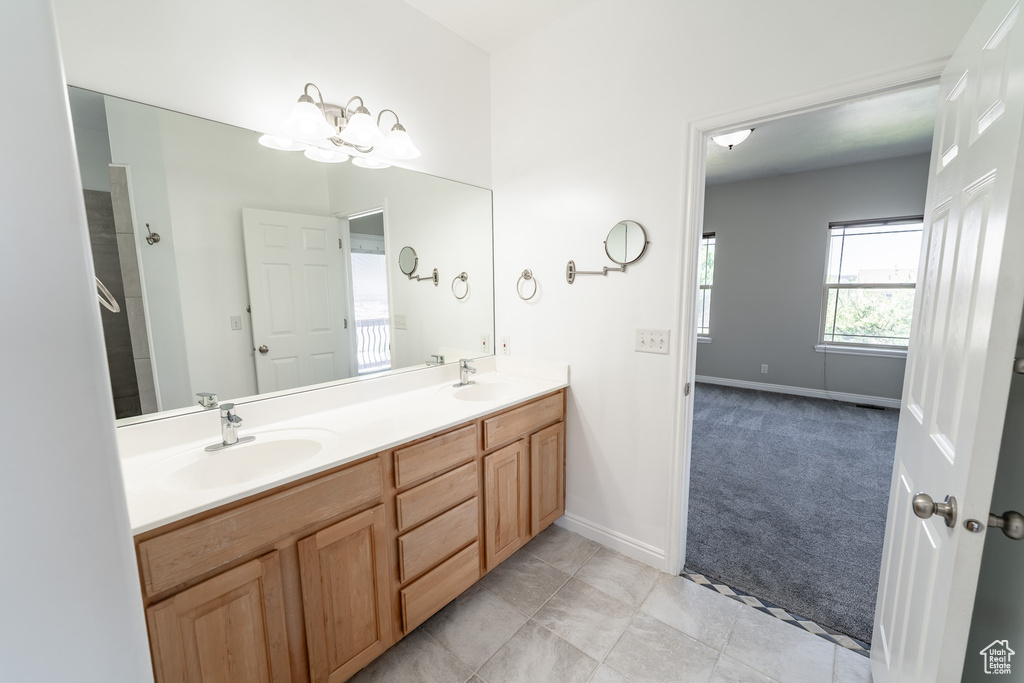 Full bathroom with double vanity and a chandelier