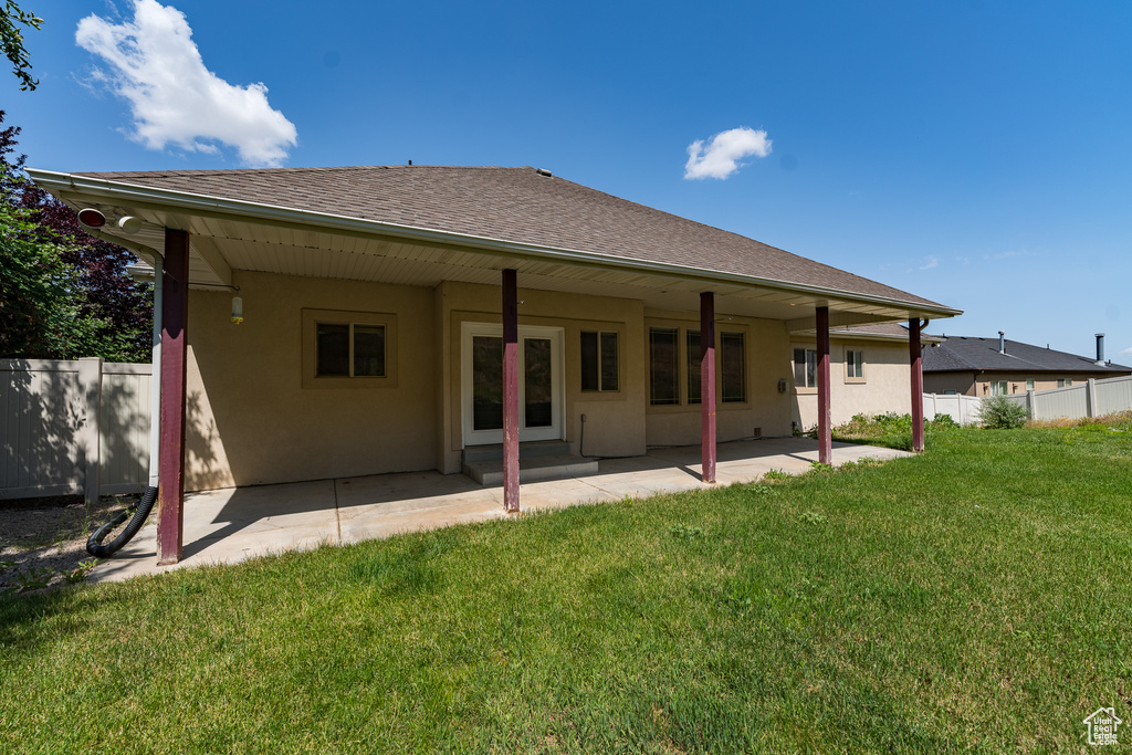 Rear view of property with stucco siding, a patio area, and roof with shingles
