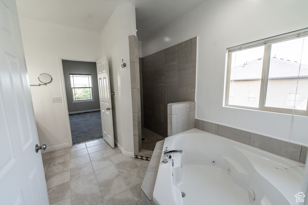 Full bath with a jetted tub, a tile shower, and tile patterned flooring