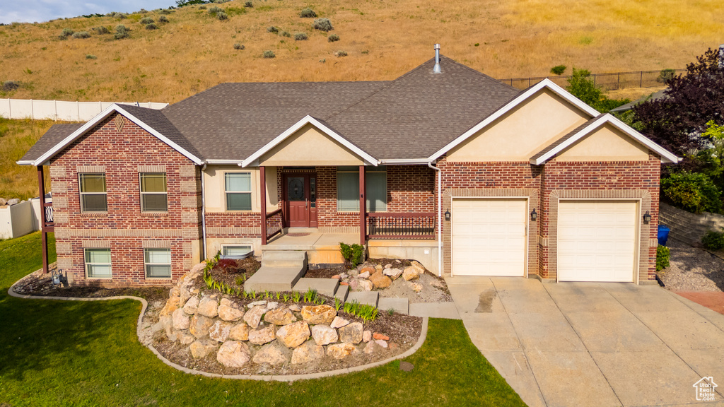 View of front of home featuring brick siding, concrete driveway, an attached garage, and roof with shingles
