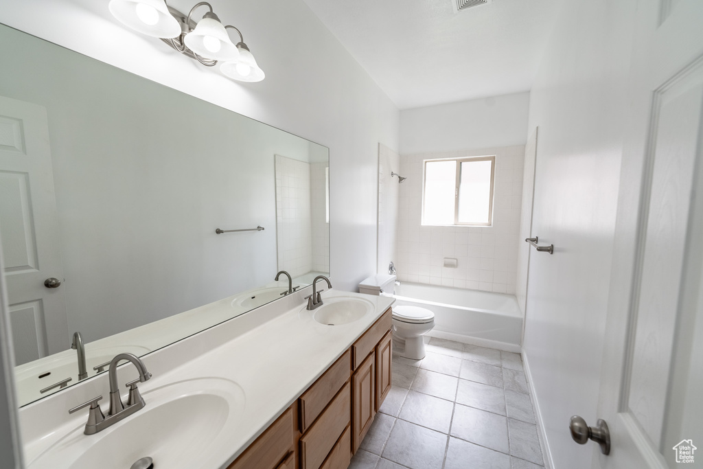 Full bathroom with double vanity, tile patterned floors, and tub / shower combination