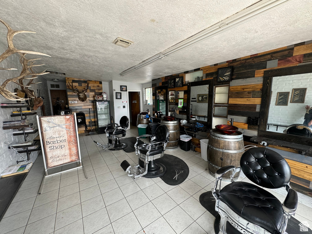 Misc room with tile patterned floors, a textured ceiling, and wood walls