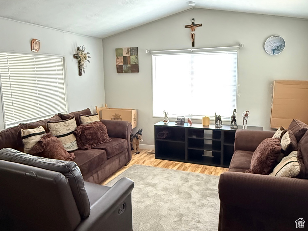Living area featuring wood finished floors, lofted ceiling, and a textured ceiling