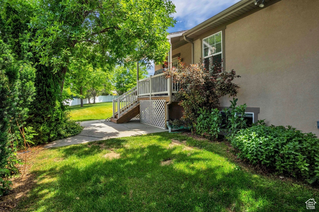 View of green lawn featuring stairway and a patio area
