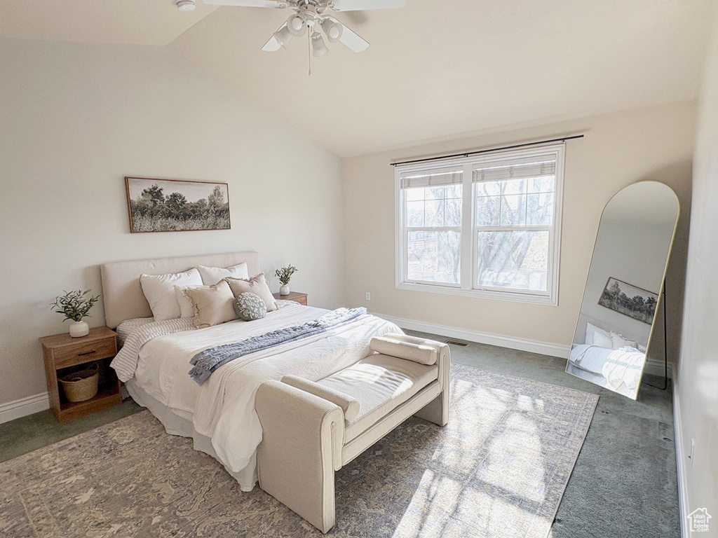 Carpeted bedroom with vaulted ceiling and a ceiling fan