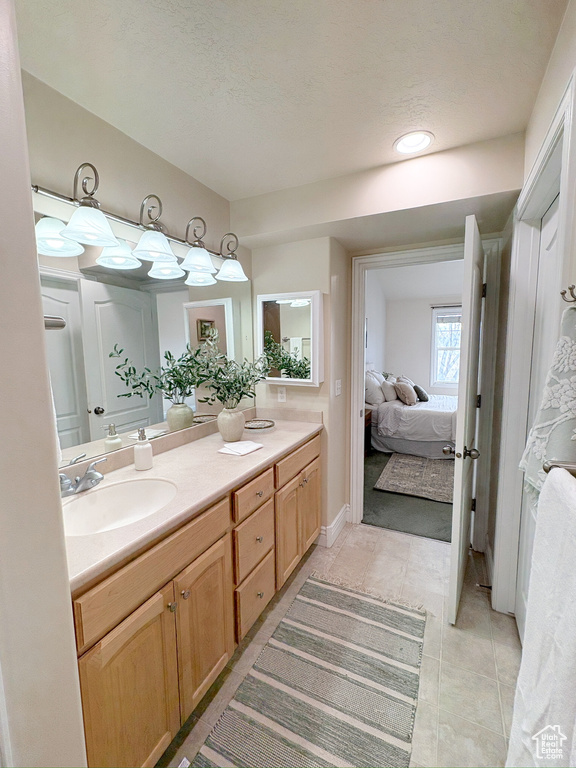 Ensuite bathroom featuring double vanity and tile patterned floors