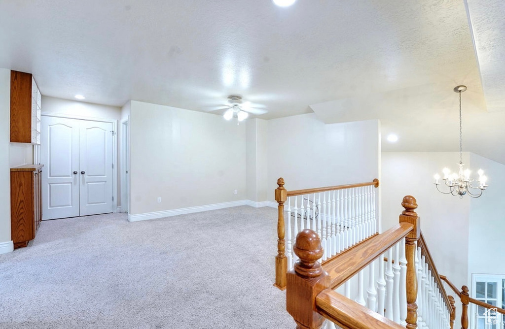 Interior space featuring a ceiling fan, light carpet, a chandelier, and recessed lighting