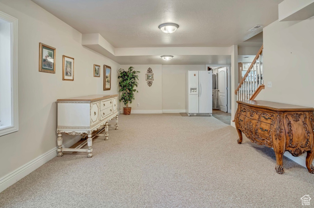 Living area featuring light carpet and stairs