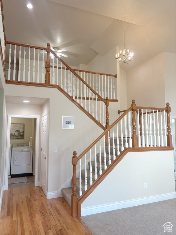 Stairway featuring washer / dryer, a chandelier, wood finished floors, a ceiling fan, and recessed lighting