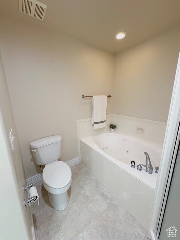 Bathroom with a jetted tub, recessed lighting, and tile patterned flooring