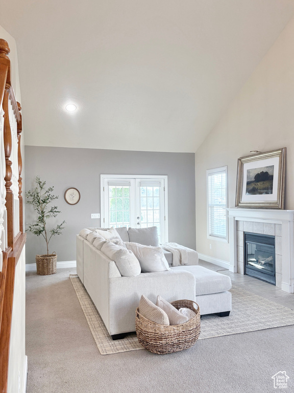 Living area with lofted ceiling, carpet flooring, a tile fireplace, and recessed lighting