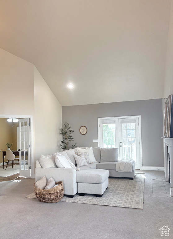 Carpeted living area featuring french doors and high vaulted ceiling