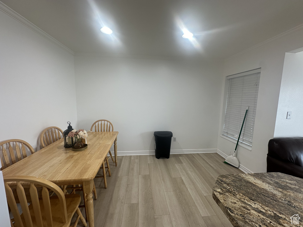 Dining room with crown molding, light wood finished floors, and recessed lighting