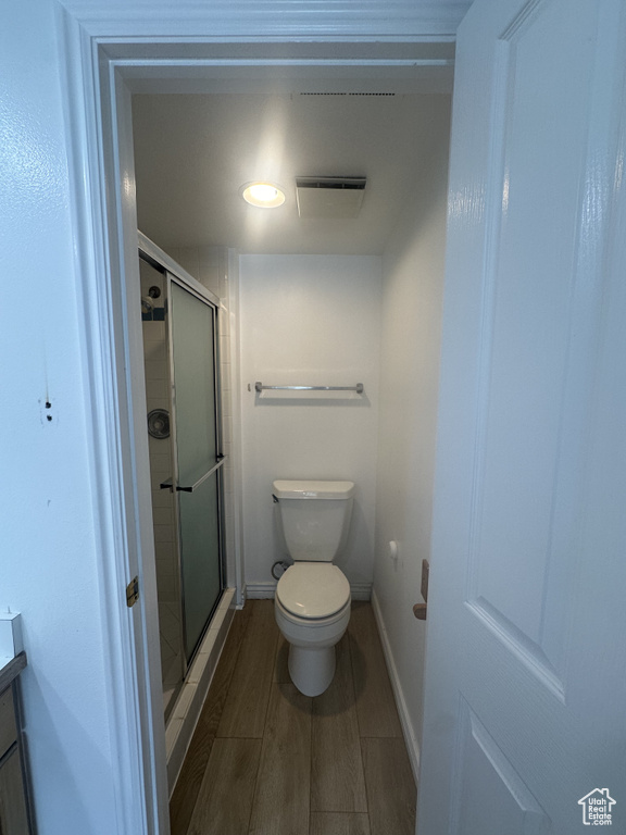 Full bathroom with a stall shower, vanity, and wood finished floors