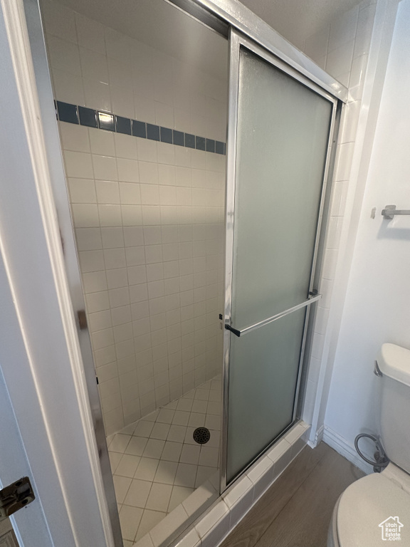 Full bathroom featuring a stall shower and wood finished floors
