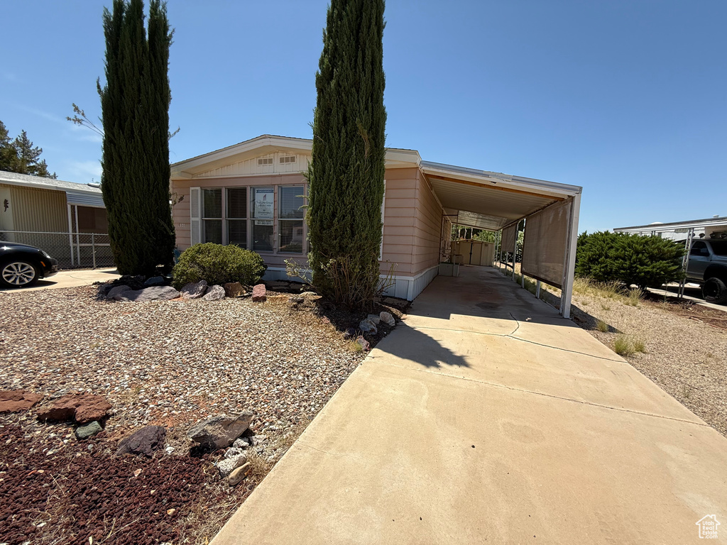 Manufactured / mobile home featuring concrete driveway and a carport