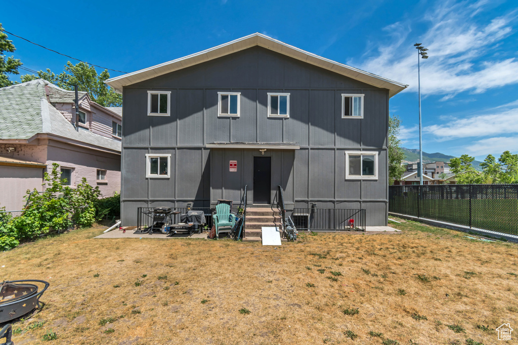 Back of house featuring entry steps and a fenced backyard