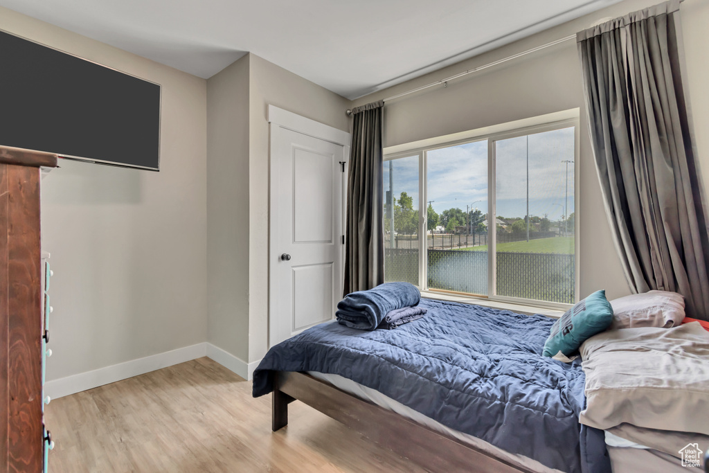 Bedroom with wood finished floors and baseboards