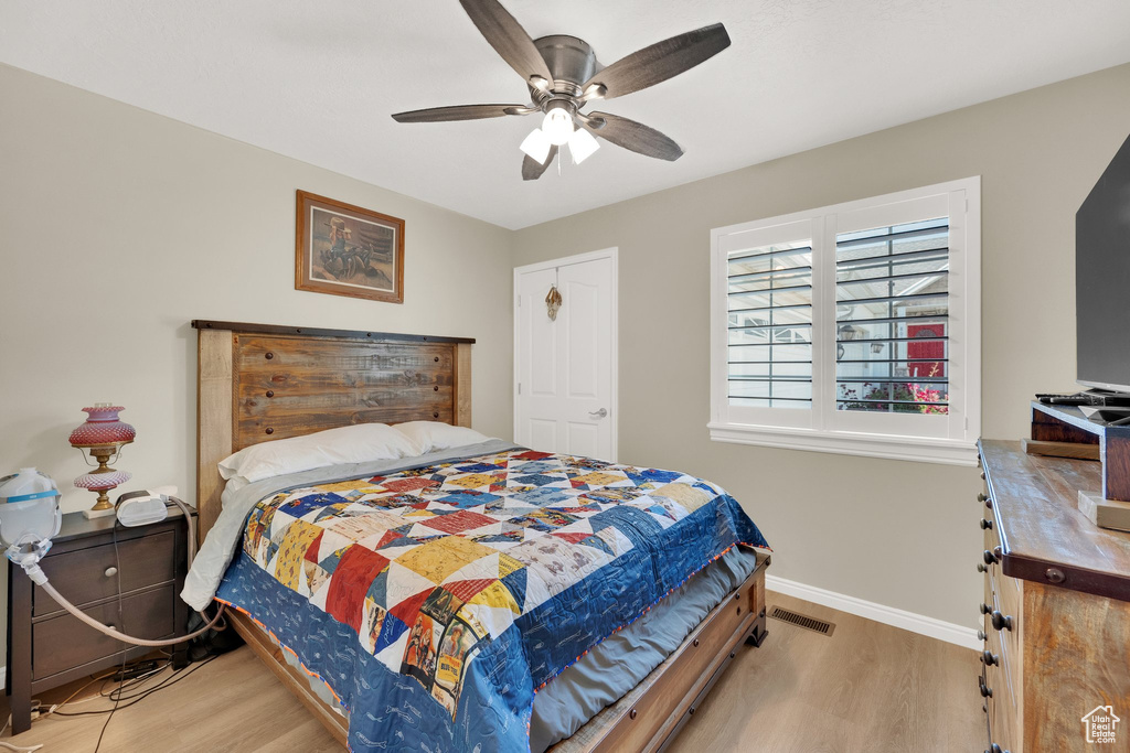 Bedroom featuring wood finished floors, baseboards, and ceiling fan
