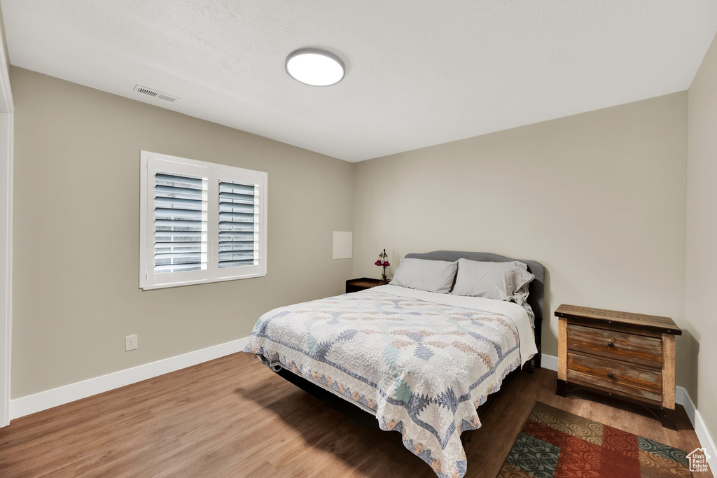 Bedroom featuring baseboards and wood finished floors