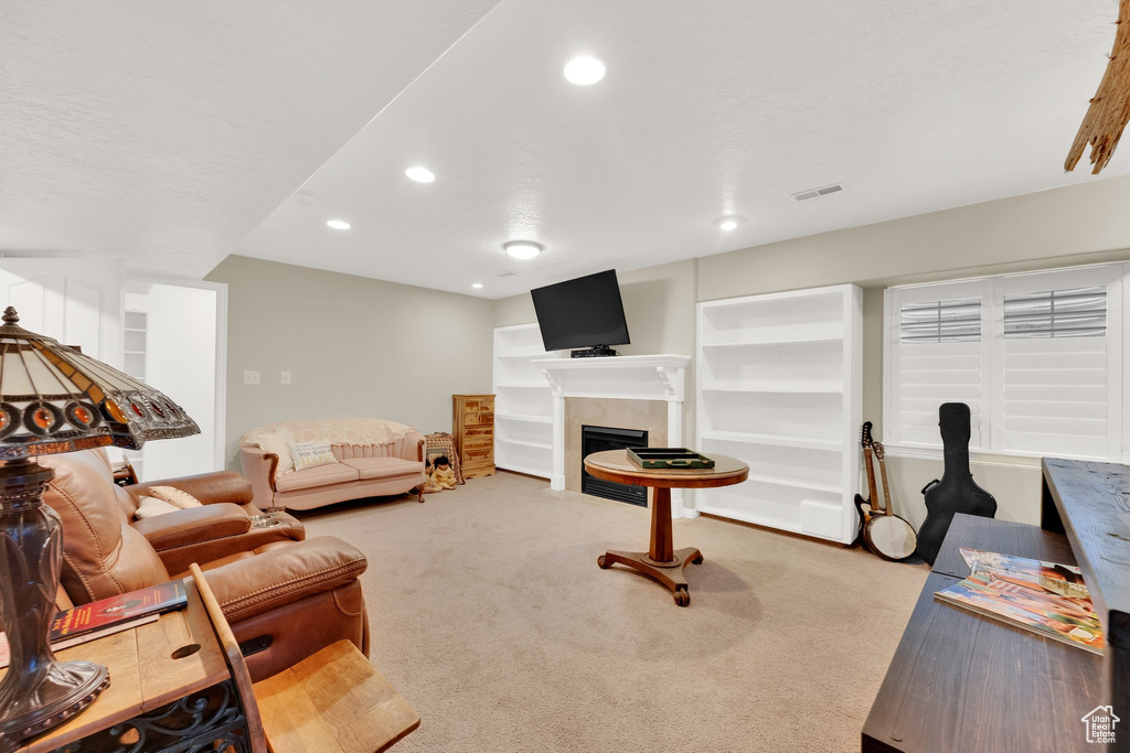 Carpeted living area featuring recessed lighting and a fireplace