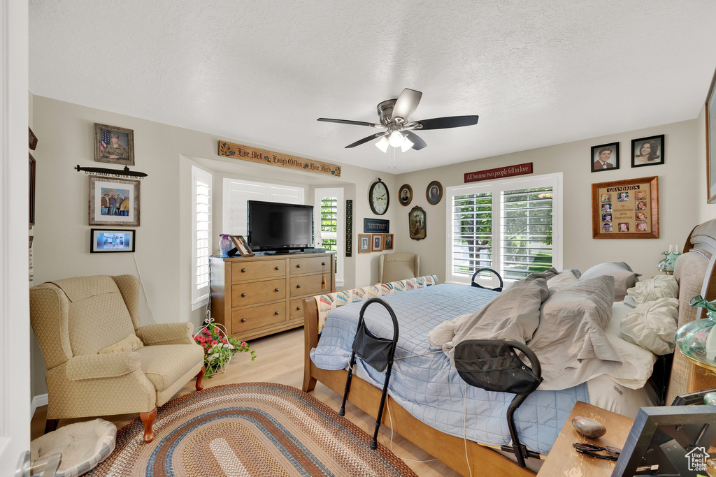 Bedroom featuring light wood-style flooring, ceiling fan, and a textured ceiling