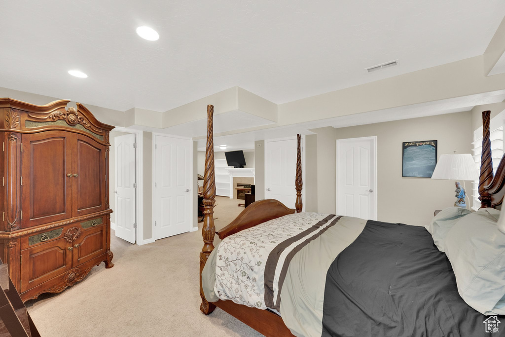 Bedroom with light colored carpet and recessed lighting