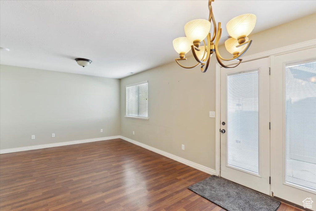 Entrance foyer with wood finished floors and a chandelier