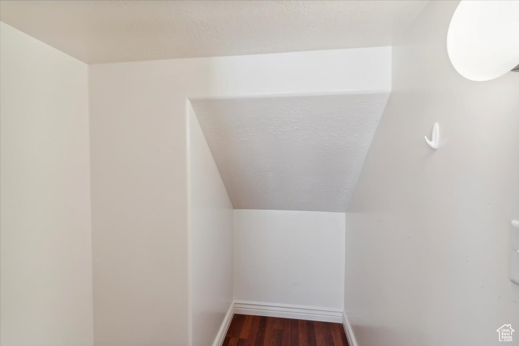 Additional living space featuring dark wood-style flooring and baseboards