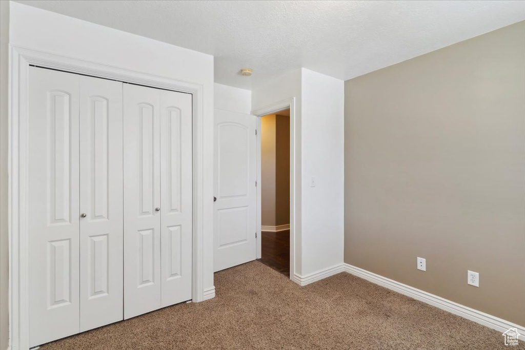 Unfurnished bedroom with carpet and a closet