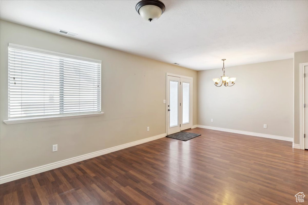 Foyer entrance with a chandelier and wood finished floors