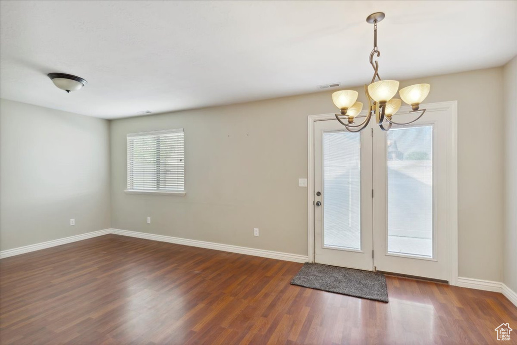 Doorway featuring a chandelier and wood finished floors