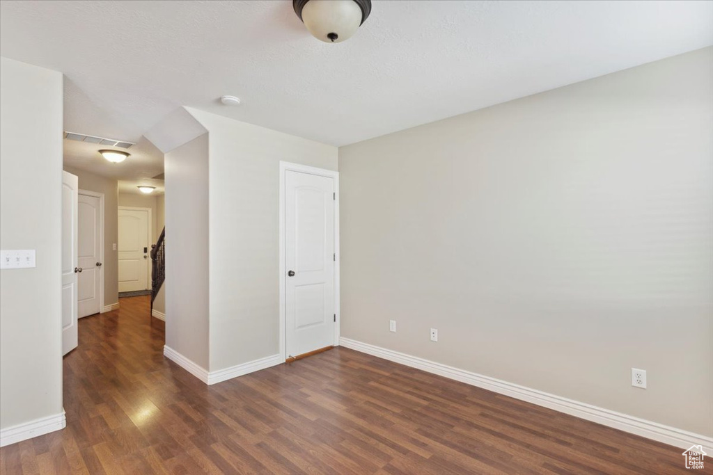 Empty room featuring wood finished floors and baseboards